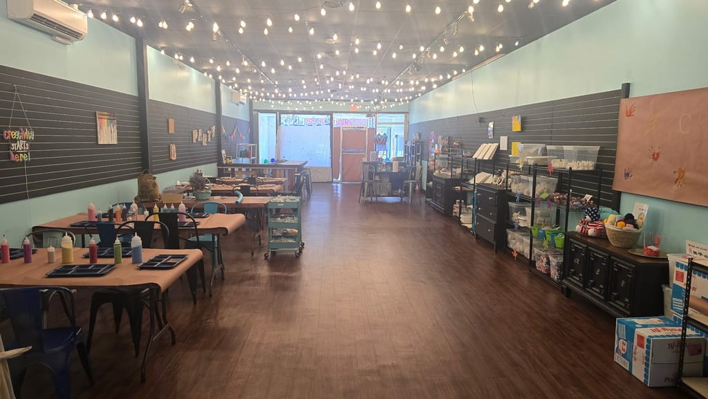 Craft tables inside our studio, with teal walls and black display boards